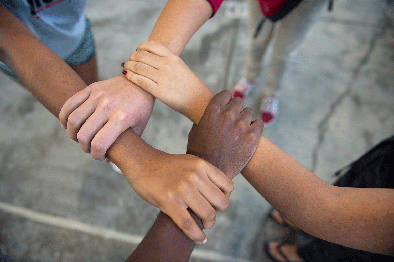 Four hands join together in a show of unity and inclusion