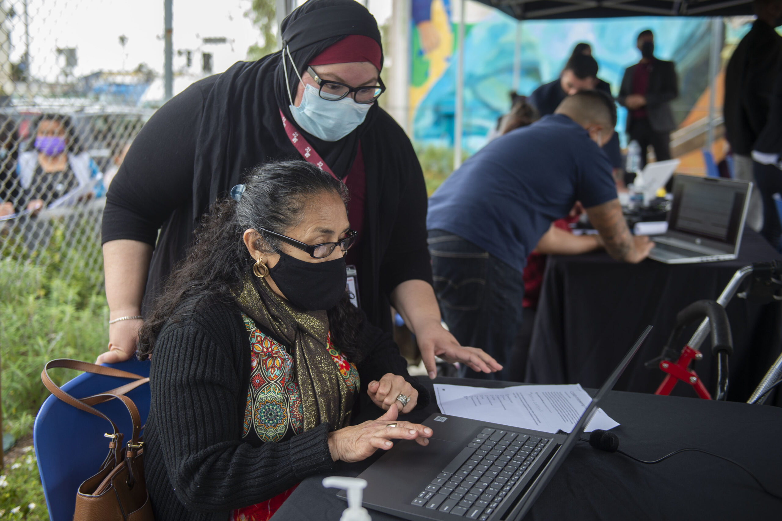 Two women collaborate at a community event, focusing on digital literacy and engagement in Los Angeles County.