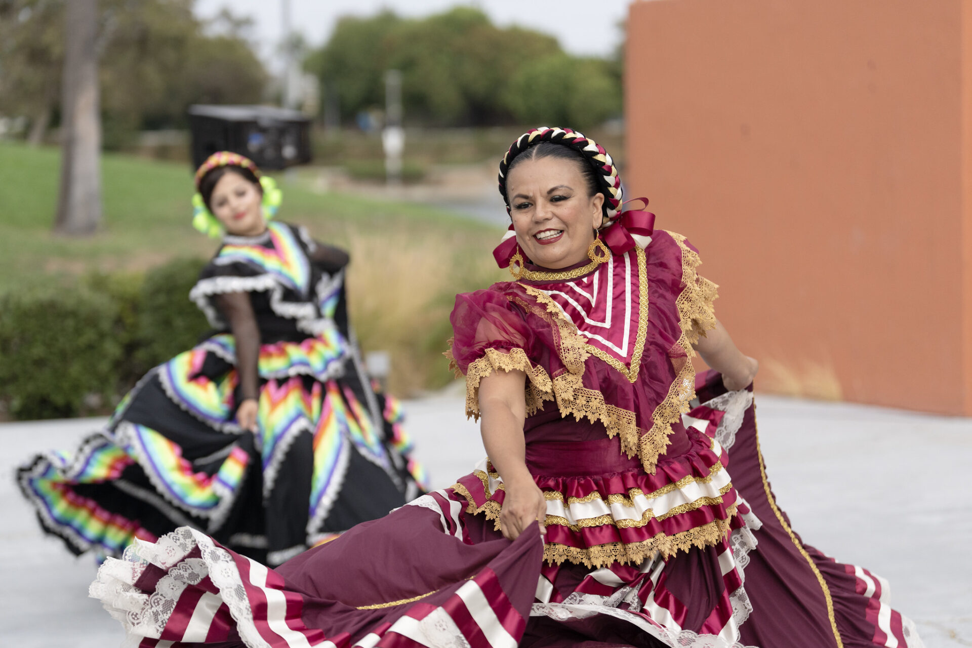 Two dancers in traditional attire perform a vibrant cultural dance, celebrating community heritage and inclusivity.