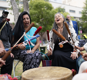 Community members joyfully participate in a drum circle, celebrating cultural heritage and unity in Los Angeles County.