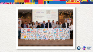 Group stands in front of three boards with text and drawings on them.