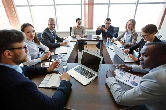 Diverse professionals engage in a collaborative meeting focused on community initiatives and strategic planning.